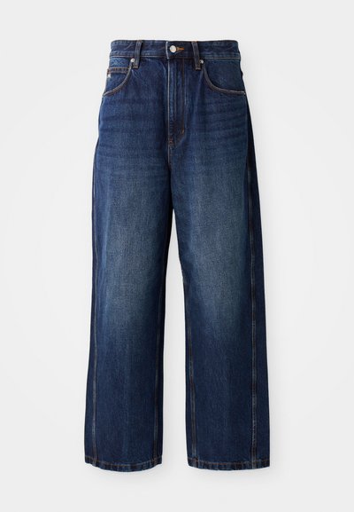 Mørkeblå vide jeans laget av denim. Har en klassisk midje med beltehemper, frontlommer og en rett silhuett.