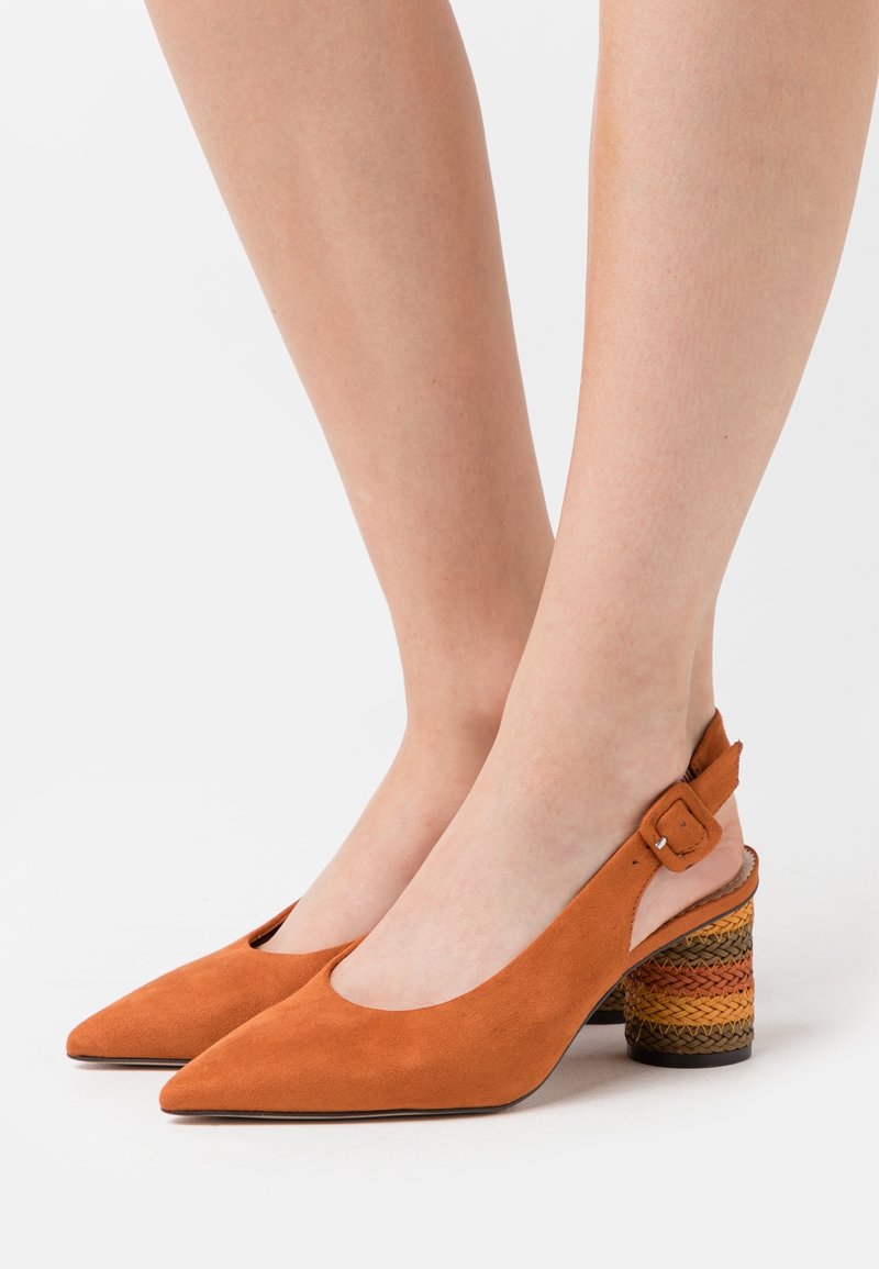 Tacones de ante naranja tipo slingback con punta afilada y un tacón apilado de colores multicolores tejido. El diseño cuenta con un corte lateral y cierre de hebilla.