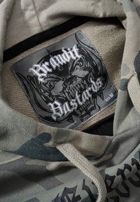Felpa con cappuccio in motivo camouflage, tonalità grigie e verdi. Presenta un'etichetta nera con un design di teschio e il testo "Brandit Bastards". Taglia M.