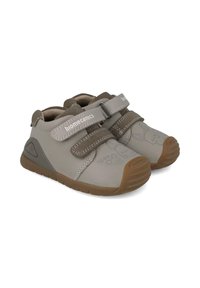 Zapatos infantiles grises con un upper sintético suave, dos cierres de tiras, suela de goma y sutiles diseños de conejito en la puntera.