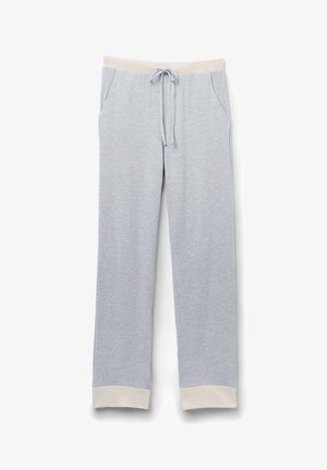 Ljusgrå mjukisbyxor tillverkade av mjukt tyg, med ett elastiskt midjeband med dragsko, sidofickor och krämfärgade muddar.