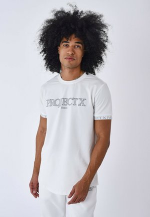 T-shirt bianco a maniche corte con logo grigio "PROJECT X" sul frontale e maniche accenti. Tessuto morbido con una texture liscia.