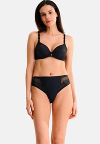 Soutien-gorge noir avec bordure en dentelle, armatures de soutien et accent décoratif doré. Culottes taille haute noires avec détails en dentelle ornés de motifs de roses.