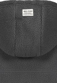 Gray fleece hoodie with a textured surface, featuring a hood and a label affixed at the back, stating "SBLVL STUDIO."