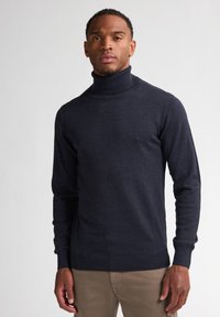 Maglione a collo alto navy in morbido tessuto a maglia, con maniche lunghe e polsini e orlo a costine. Texture liscia con una silhouette aderente.