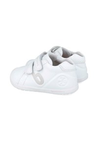 Zapatos infantiles blancos con un acabado de cuero suave, que presentan acentos grises, correas de velcro y un interior suave y acolchado.