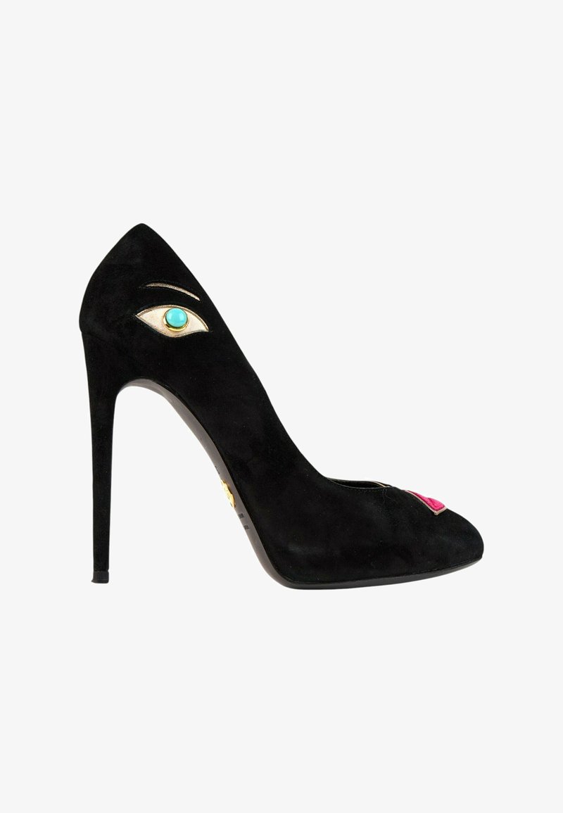 Chaussure noire à talon haut avec un motif œil turquoise près du talon et un détail de lèvres roses sur l'orteil, sur fond blanc.