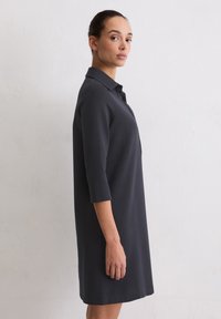 Ciemnoszara sukienka do kolan z kołnierzykiem i rękawami do łokcia. Gładka faktura, prosta sylwetka i minimalne zdobienia.