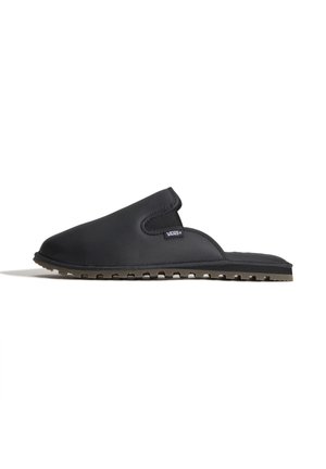 Mule noire à enfiler avec dessus matelassé, semelle texturée et étiquette du logo Vans sur le côté.