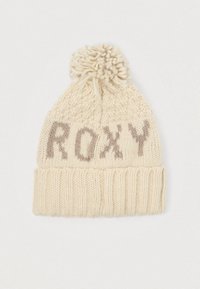Pletená čiapka v krémovej farbe s jemnou textúrou, ktorá má na vrchole pom-pom a na prednej strane je vyšitý nápis "ROXY" svetlohnedej farby.
