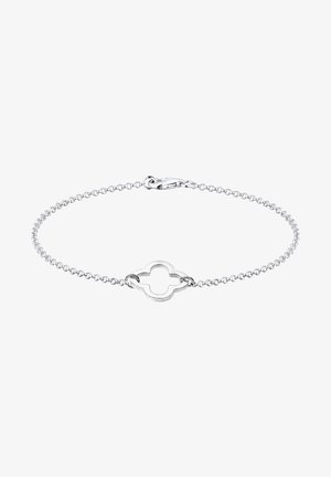 Bracelet chaîne en argent avec un pendentif central ouvert en forme de quadrilobe et une fermeture à mousqueton sur fond blanc.