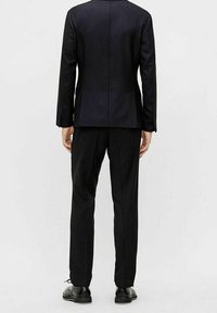 Czarna garniturowa marynarka z dopasowanymi spodniami. Tkanina wydaje się gładka, o czystym wzornictwie, bez widocznych wzorów czy akcentów.