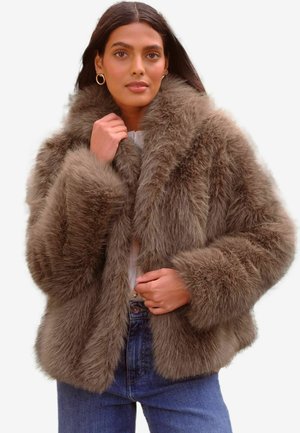 Faux-Fur-Jacke in einer sanften Braunnuance, ausgestattet mit einem breiten Kragen, voluminösen Ärmeln und einer entspannten Passform, ergänzt durch ein leichtes Innenfutter.