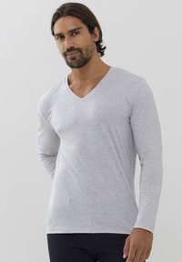 T-shirt a maniche lunghe e scollo a V in grigio chiaro, realizzato in tessuto morbido. Presenta un design pulito senza motivi o accenti.