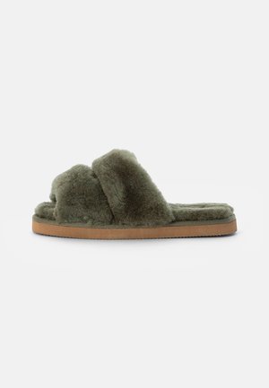 Chausson mule en fausse fourrure vert olive avec une semelle épaisse et des brides doubles superposées sur fond blanc.