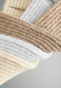 Vlněný šátek v krémové, šedé a světle hnědé barvě. Texturovaný, hřebínkový vzor s různými odstíny. Měkká a silná tkanina.