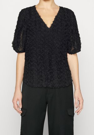 Zwarte textuurbloes met korte mouwen en bloemenpatroon, V-hals, gecombineerd met zwarte cargobroek.