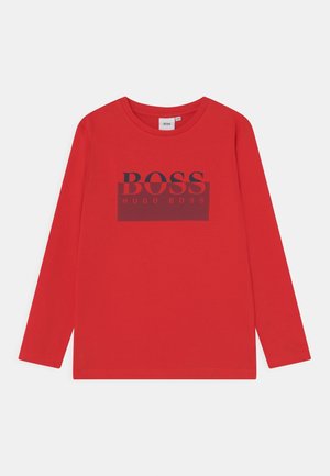 Czerwona koszula z długim rękawem i okrągłym dekoltem, z logo "BOSS HUGO BOSS" w ciemnych literach na wysokości klatki piersiowej.