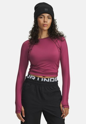 Fitted long-sleeve top in deep pink with contrasting black stitching, paired with black drawstring pants featuring a bold white logo waistband.