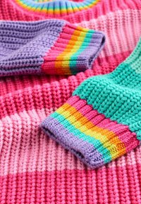 Bunt gestricktes Kleidungsstück mit rosa, lila und grünen Streifen. Strukturiertes Gewebe mit gerippten Bündchen und lebhaften Regenbogenakzenten.