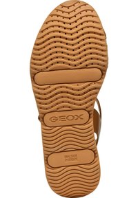 Suela de sandalia de goma marrón con patrones en forma de ola y círculo; presenta "GEOX" y "PATENTE ITALIANA" impresos; superficie texturizada para mayor agarre.