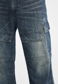 Donkerblauwe cargobroek van denim met meerdere zakken, zichtbare naden, een licht versleten textuur en een regular fit ontwerp.