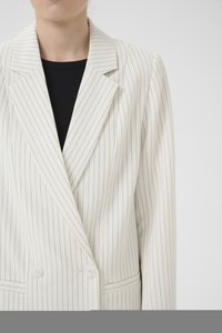 White pinstriped blazer with a double-breasted design, notched lapels, and two front buttons. Tailored fit with a smooth texture.
