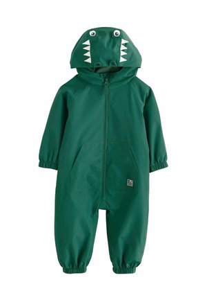 Salopette de pluie verte avec capuche sur le thème des dinosaures, présentant des dents et des yeux blancs. Comprend des poignets élastiques et deux poches frontales. Matériau imperméable.