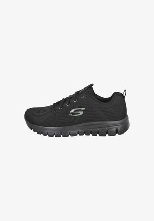 Zapatilla deportiva negra de Skechers con sistema de cordones en la parte frontal, parte superior de malla, suela gruesa con ranuras y un logotipo plateado "S" en el lateral.