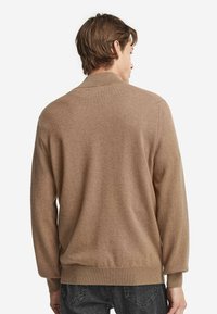 Brauner Strickcardigan mit lockerer Passform, gerippten Bündchen und Saum sowie einer glatten Textur, von hinten gegen einen neutralen Hintergrund betrachtet.