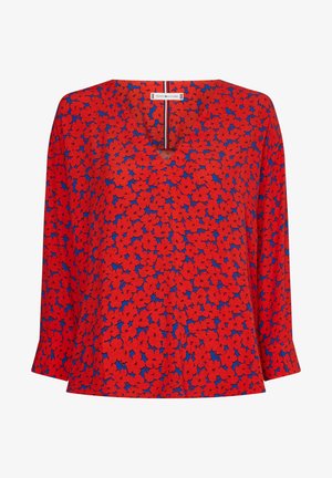 Red long-sleeve blouse with blue background and dense red floral pattern, V-neckline, and Tommy Hilfiger label inside collar.