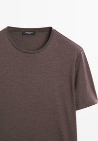 Brun kortærmet T-shirt lavet af blødt stof med rund halsudskæring. Teksturen ser glat ud med et subtilt meleret mønster.