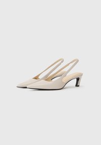 Beežid slingback kontsad, terava nina, mõõdukas must plokk konts ja sile nahka meenutav tekstuur. Peened rihmad sobivuse tagamiseks.