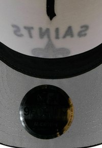 Black and white baseball cap with a gray crown, featuring “SAINTS” in bold print and a round New Era logo sticker on the brim.