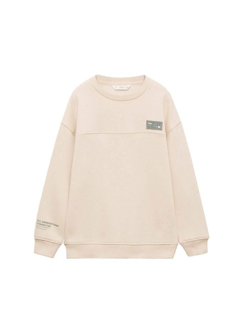 Sweatshirt beige en tissu doux, avec une couture horizontale et une petite étiquette sur la poitrine. Le texte sur la manche indique "TOUTES LES GÉNÉRATIONS CONNECTÉES."