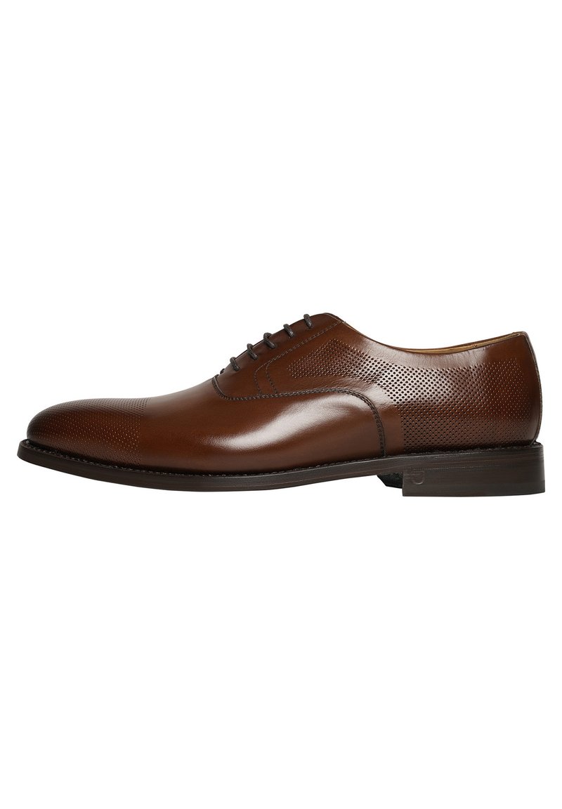 Chaussure habillée en cuir marron avec une finition lisse, côtés perforés, bout rond et un talon bas. Dispose d'un laçage traditionnel.