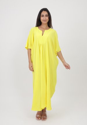 Robe kaftan jaune avec un col en V, des manches courtes et un design fluide. Fabriquée en tissu léger et texturé, atteignant la longueur mi-mollet.