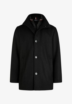 Must mustrüüga, millel on kõrge krae, nuppude sulgemine ja kaks küljetaskut. Valmistatud tekstureeritud kangast, metallnupud ja aktsendid.