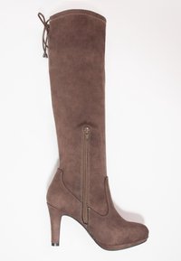 Bota de ante marrón hasta la rodilla con un diseño ajustado, un cierre lateral con cremallera y un tacón alto. Presenta una punta redondeada y costuras decorativas en la parte superior.