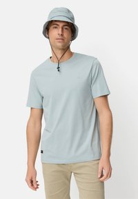 Lichtblauw T-shirt met korte mouwen gemaakt van zachte stof, gecombineerd met een bijpassende buckethoed met koordsluiting. Eenvoudig ontwerp en strakke lijnen.