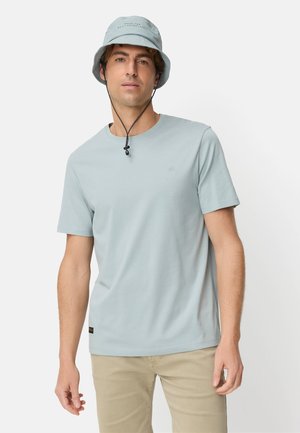 Lichtblauw T-shirt met korte mouwen gemaakt van zachte stof, gecombineerd met een bijpassende buckethoed met koordsluiting. Eenvoudig ontwerp en strakke lijnen.