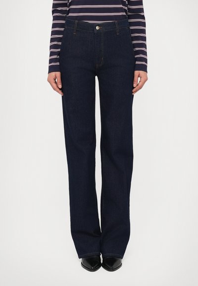 Jean en denim bleu foncé à jambes larges avec une taille haute, doté d'une fermeture à boutons sur le devant, de coutures classiques et d'une texture lisse.