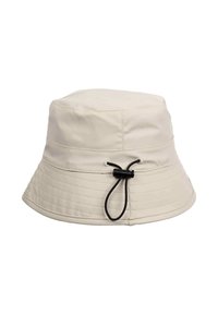 Cappello a secchiello beige realizzato in materiale impermeabile con una parte superiore arrotondata, visiera ampia e corda regolabile nera sul retro. Superficie testurizzata.