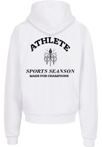 Biely mikina s kapucňou s nápisom "ATHLETE" v tučnom čiernom písmene nad grafickým dizajnom. Obsahuje rebrované manžety a lem pre tesný strih.