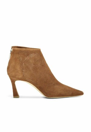 Bruine suède enkellaars met puntige neus, geperforeerd ontwerp, hak van gemiddelde hoogte en een ritssluiting aan de achterkant.