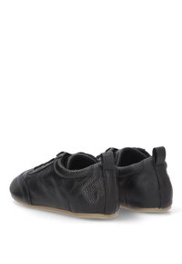 Zapatos de cuero negro con un acabado texturizado, punta redondeada y un diseño minimalista. Presenta un talón bajo y suela de goma flexible.