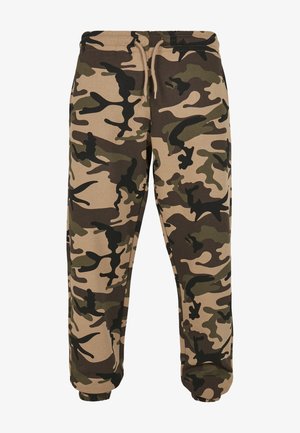 Pantalones de chándal de camuflaje en tela marrón, verde y beige. Presentan una cintura elástica con cordón y puños ajustados en los tobillos.