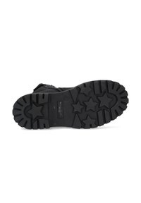 Suela de bota de goma negra con una superficie texturizada que presenta estrellas elevadas y ranuras para mayor tracción. Duradera y diseñada para terrenos variados.