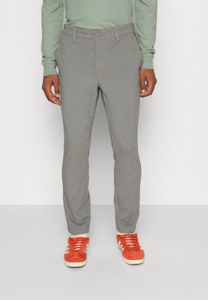 Gray tailored pants with a smooth texture, button closure, and side pockets, paired with orange athletic shoes.