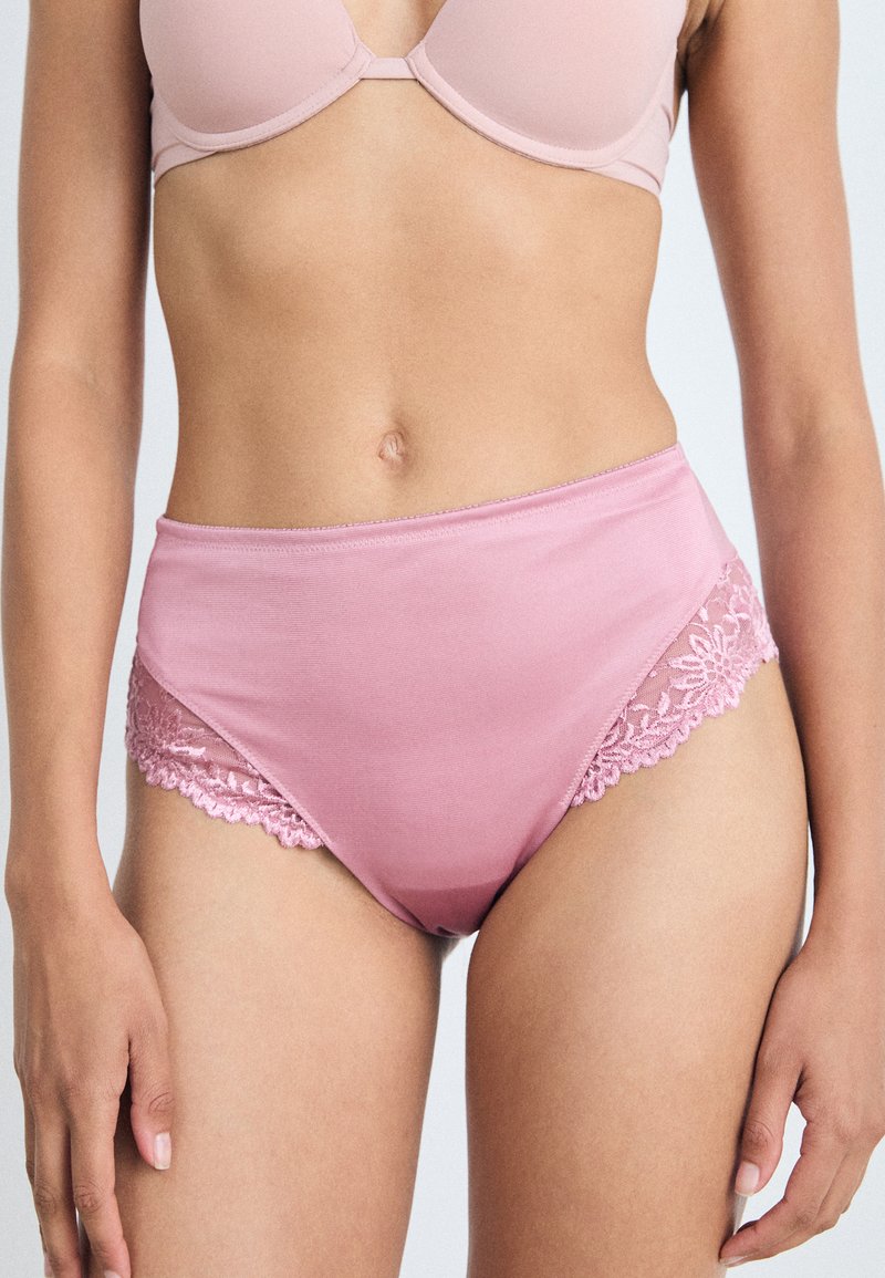 Vysoké růžové kalhotky z hladkého materiálu se květinovými krajkovými detaily po stranách, které kombinují pohodlí a jemné detaily.